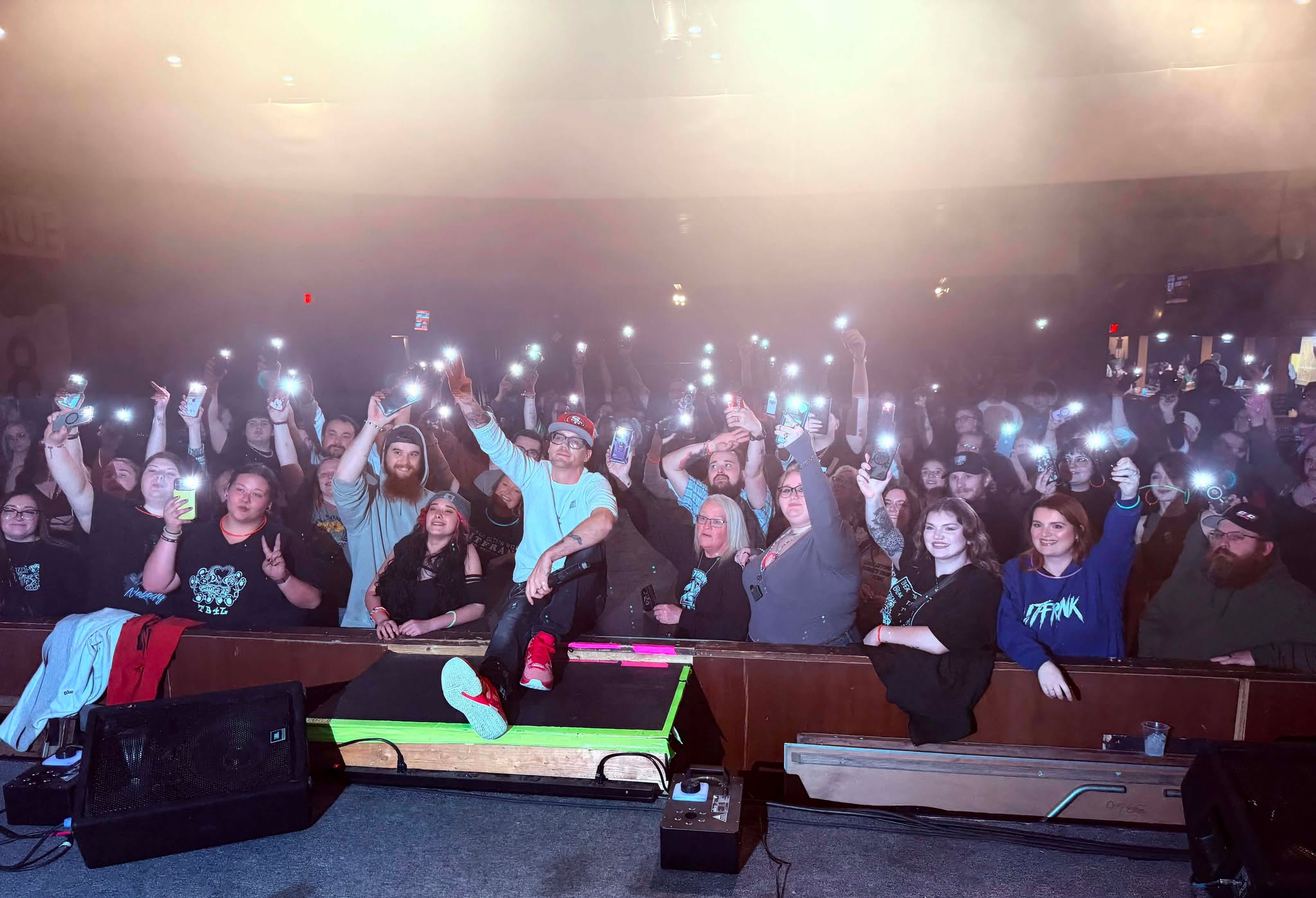 Crowd holding phone lights toward the stage.