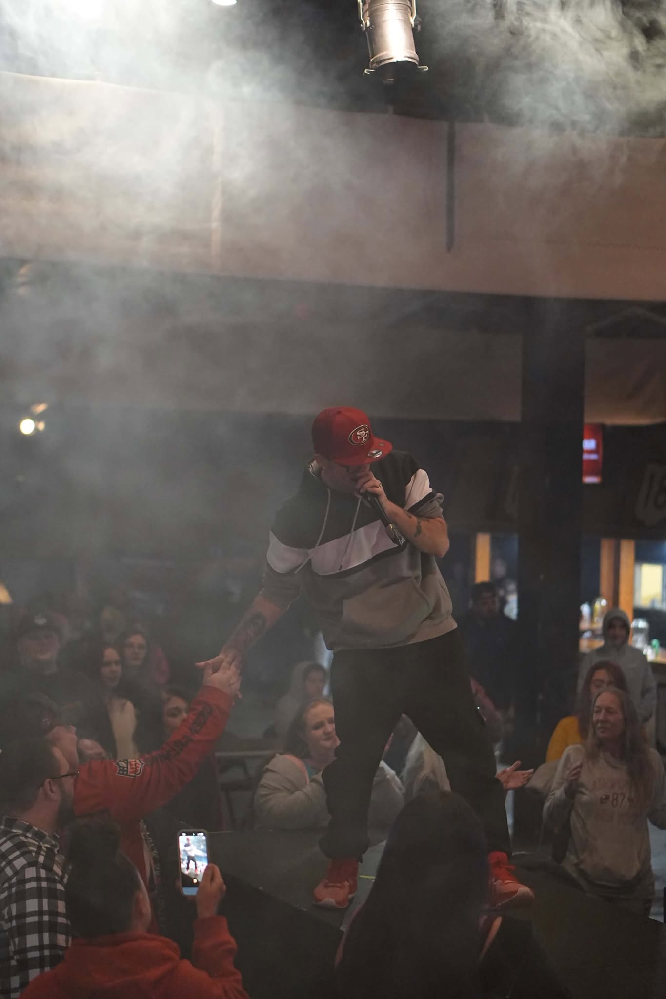 Brian Durst performing on a smoky stage under bright lights.