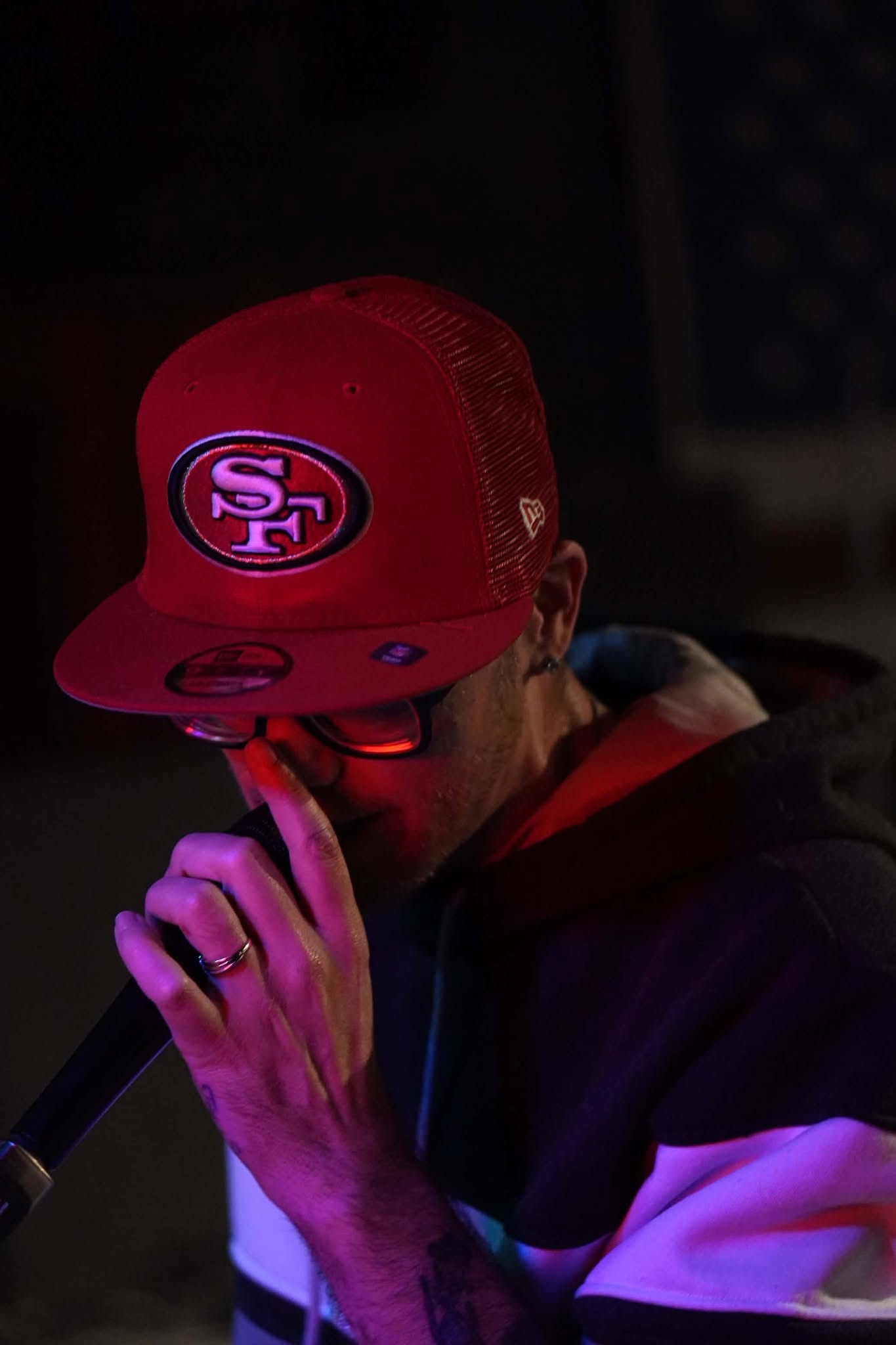 Brian Durst in a red cap under low stage lighting.