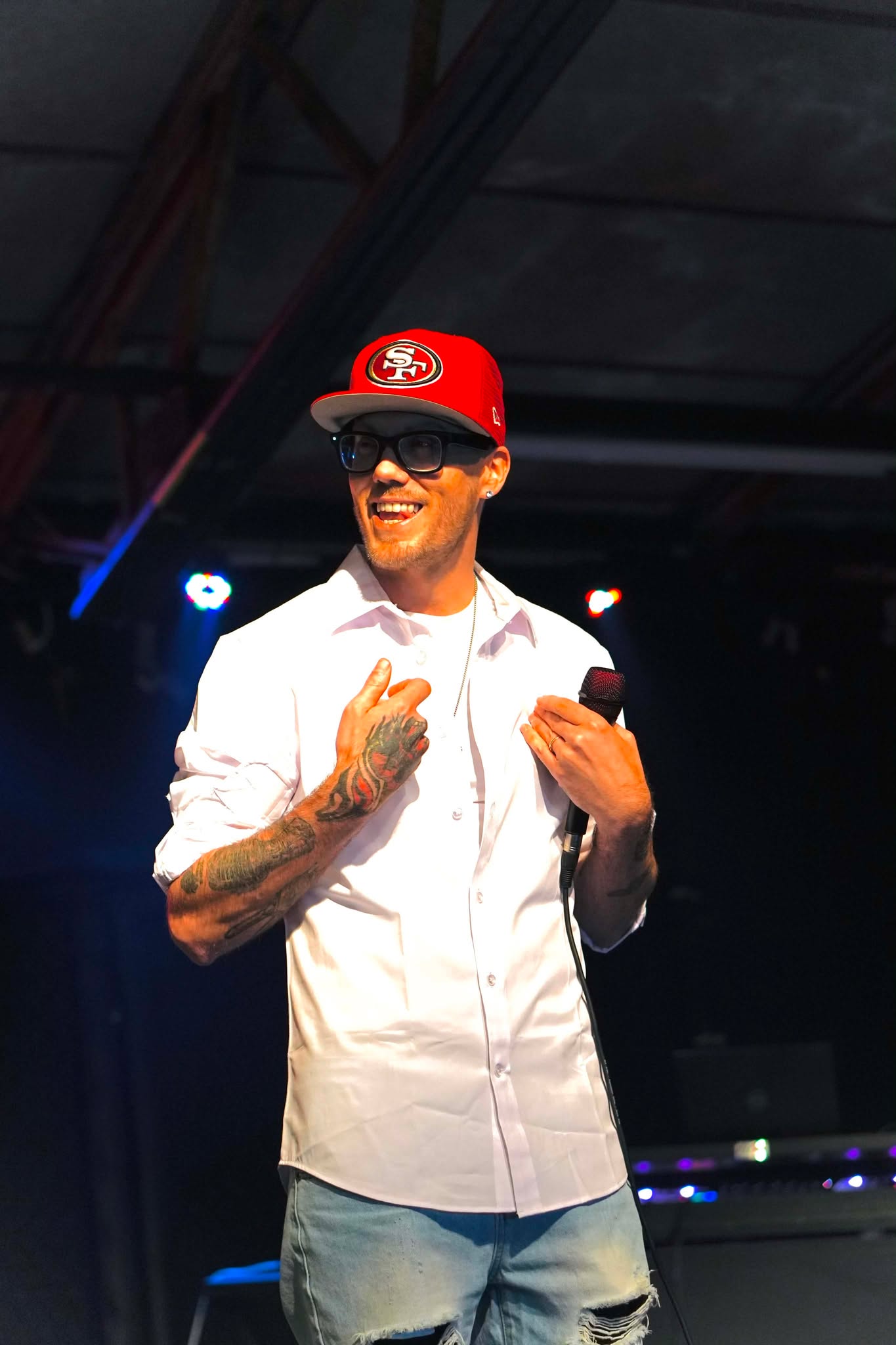Brian Durst smiling on stage with a microphone.